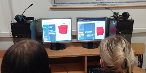 Uczennice ustawiają parametry wydruku na komputerze.