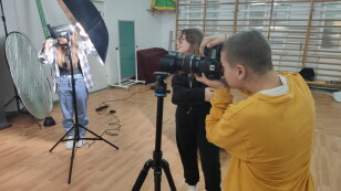 Uczeń wykonują zdjęcia aparatem fotograficznym.