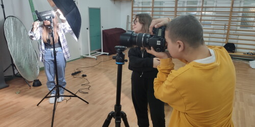 Uczeń wykonują zdjęcia aparatem fotograficznym.