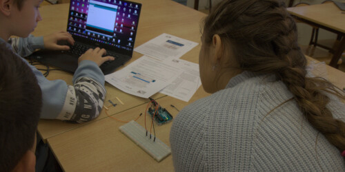 Uczeń wprowadza treść programu do komputera. Uczennica dydktuje uczniowi polecenia do wykonania dla mikrokontrolera.