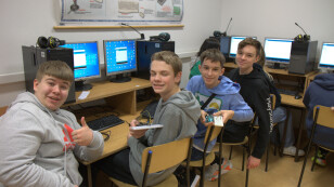 Uśmiechnięci uczniowie prezentują przygotowane mikrokontrolery do testów.