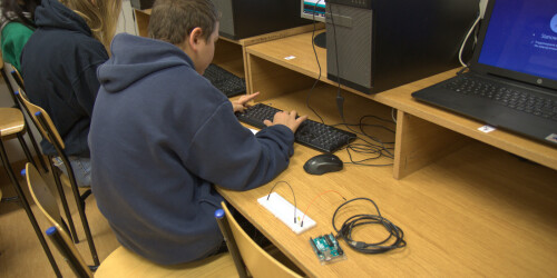 Uczeń z wykorzystaniem komputera i oprogramowania programuje zadania dla mikrokontrolera.