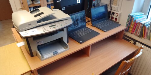 Biurko z laptopami i drukarką.