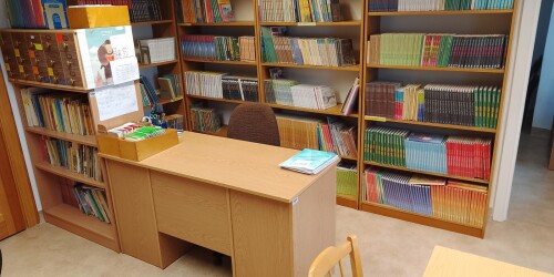 Regały z książkami, biurko bibliotekarza.