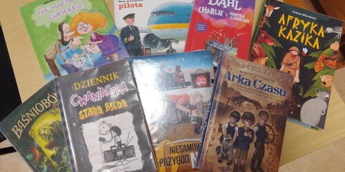 Książki leżące na stole, różne tytuły z literatury młodzieżowej i dziecięcej.
