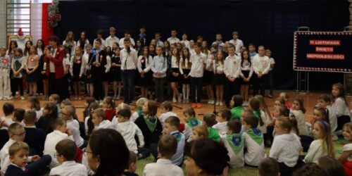 Chór szkolny śpiewa piosenkę podczas szkolnej uroczystości.