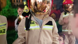 Uczeń w stroju strażaka i kasku do zadań specjalnych.